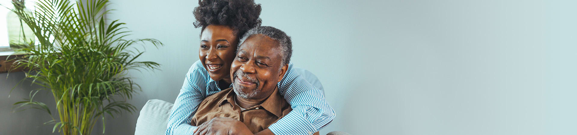Woman hugging her senior father at home
