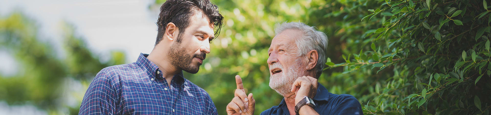 A senior man and his son have a discussion outside