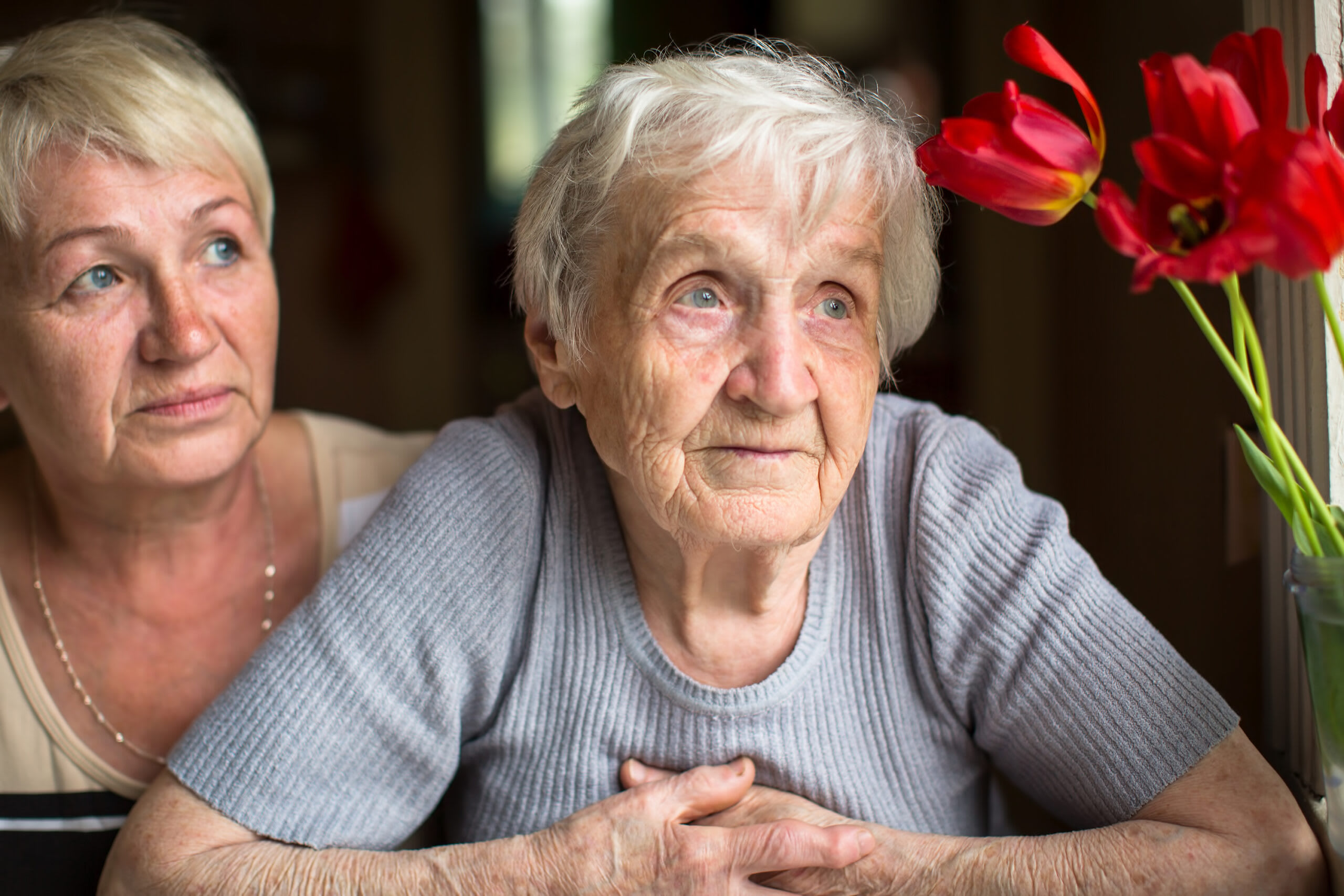 Adult daughter sitting with elderly mom