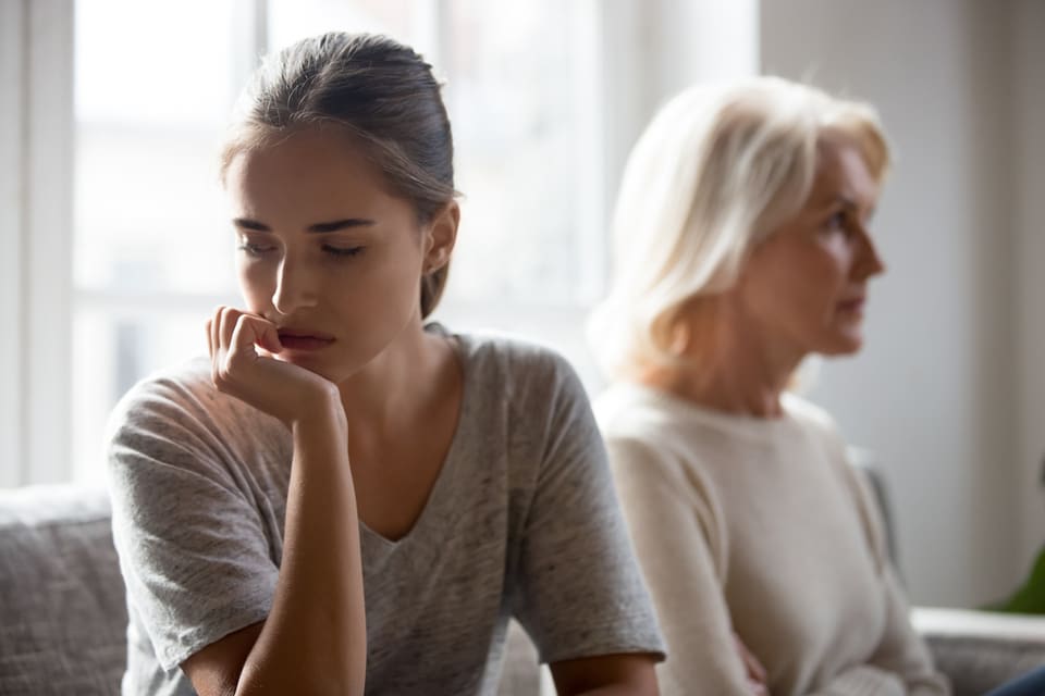 A woman sits with her senior mother.